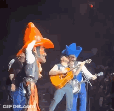 Man In Cowboy Hat Playing Guitar On Stage GIF