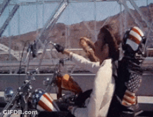 Man In Cowboy Hat Riding Motorcycle With American Flag GIF