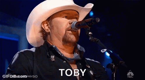 Man In Cowboy Hat Singing Into Microphone With Word Toby GIF