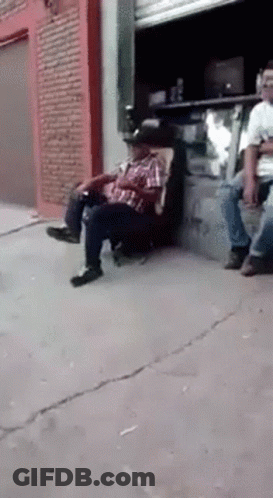 Man In Cowboy Hat Sitting On Sidewalk Chair GIF