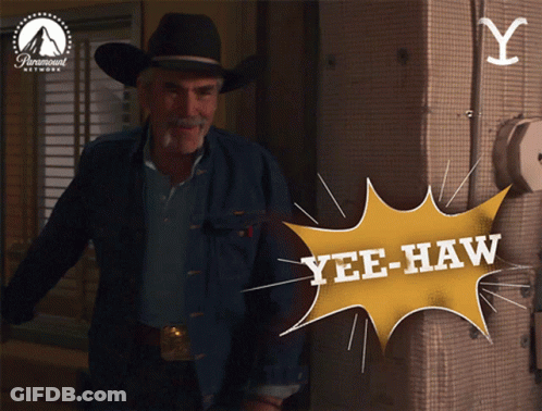 Man In Cowboy Hat Standing In Front Of Yellow Yee-Haw Sign GIF