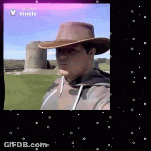Man In Cowboy Hat Taking Selfie In Front Of Castle GIF
