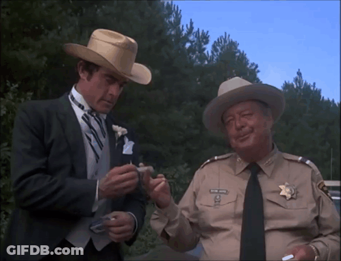Man In Cowboy Hat Talking To Man In Suit GIF