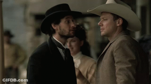 Man In Cowboy Hat Talking To Suit GIF