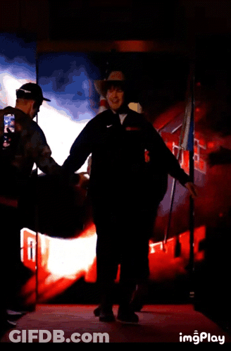 Man In Cowboy Hat Walking With American Flag GIF