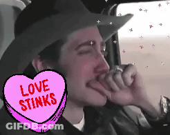 Man In Cowboy Hat With Love Stinks Heart GIF