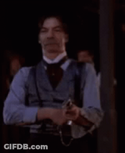 Man In Cowboy Outfit Holding Gun GIF