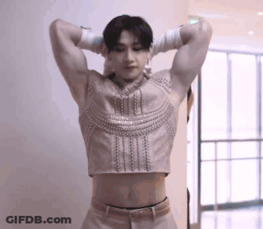 Man In Crop Top And Gloves Hands Behind Head GIF