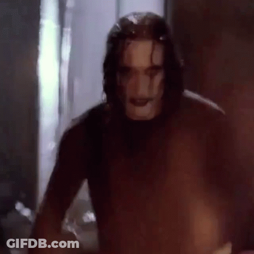 Man In Crow Mask Standing In Dark Room GIF