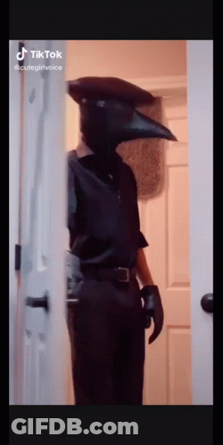Man In Crow Mask Standing In Doorway GIF