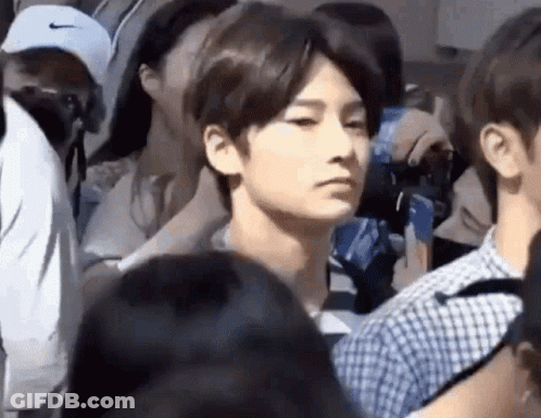 Man In Crowd Looking At Camera GIF