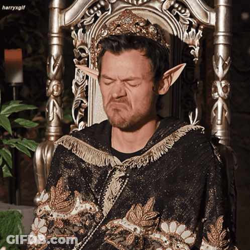 Man In Crown And Elf Ears Sitting On Chair GIF