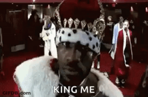 Man In Crown And Fur Coat Saying King Me On Red Carpet GIF