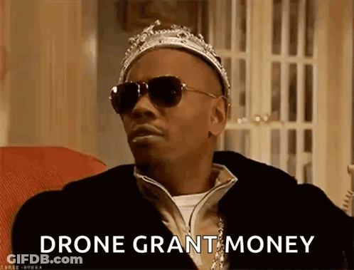 Man In Crown And Sunglasses On Couch Says Drone Grant Money GIF