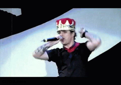 Man In Crown Holding Microphone In Mouth GIF