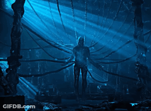 Man In Dark Room With Blue Light Through Ceiling GIF