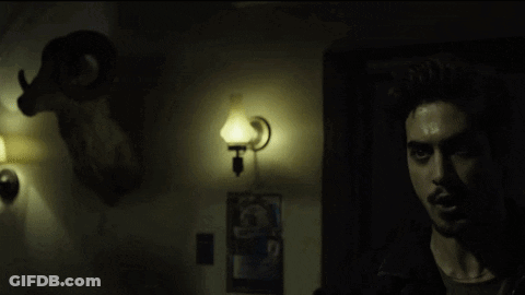 Man In Dark Room With Glowing Eyes GIF