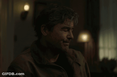 Man In Dark Room With Lamp Behind GIF