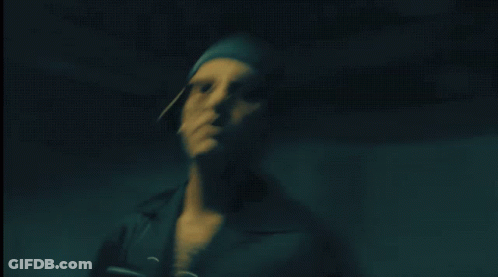 Man In Dark Room With Light On Shoulder GIF