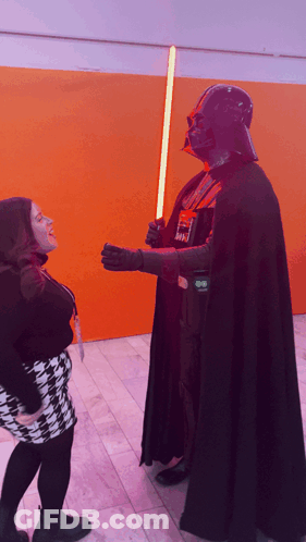 Man In Darth Vader Costume Holding Light Saber GIF