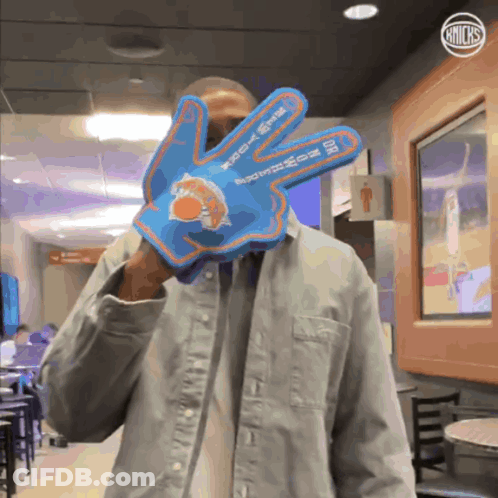 Man In Denim Jacket Holding Blue New York Knicks Glove GIF