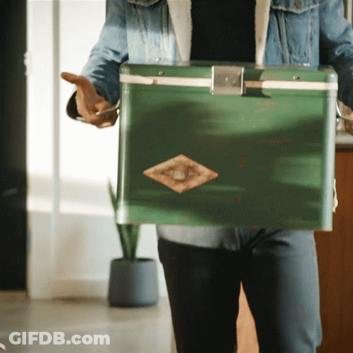 Man In Denim Jacket Holding Green Cooler With Diamond GIF