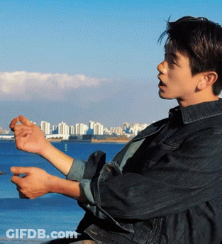 Man In Denim Jacket Looking Over Water GIF