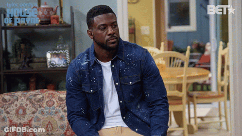 Man In Denim Jacket On Couch In Front Of House Of Payne Sign GIF