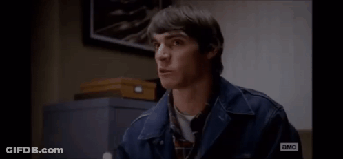 Man In Denim Jacket Sitting By Sign Saying I Am A MC GIF