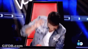 Man In Denim Jacket Sitting On Red Chair On TV Show GIF