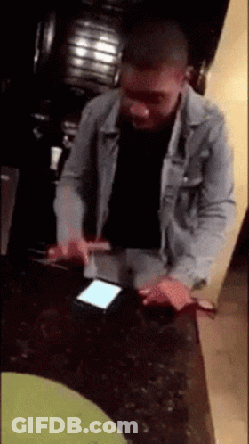 Man In Denim Jacket Using Phone GIF