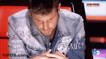 Man In Denim Jacket With Rock GIF