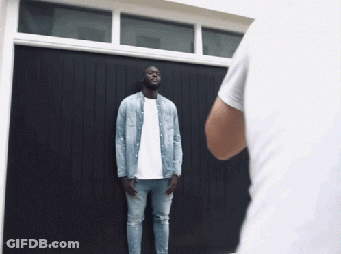 Man In Denim Shirt At Garage Door GIF