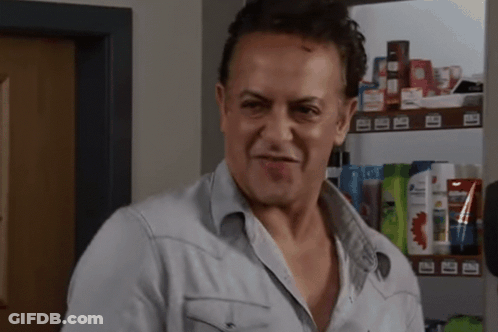 Man In Denim Shirt Standing In Front Of Shampoo Shelf GIF