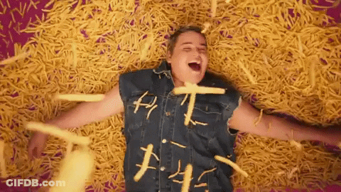Man In Denim Vest Laying On French Fries GIF