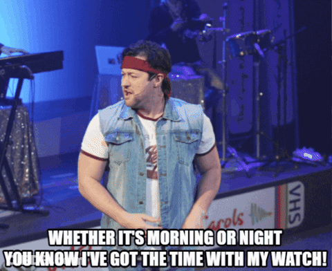 Man In Denim Vest On Stage With VHS Sign GIF