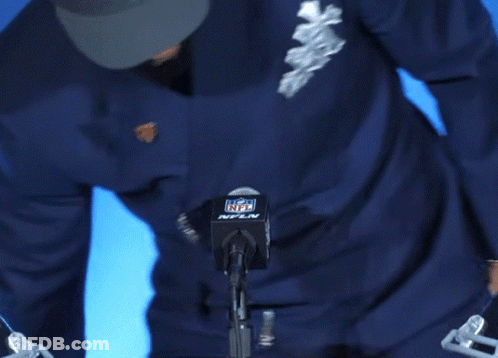 Man In Denver Broncos Hat In Front Of NFL Logo GIF