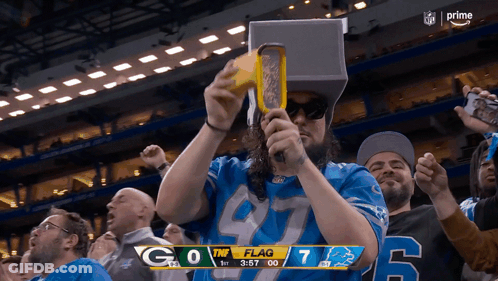 Man In Detroit Lions Jersey Holding Yellow Object GIF
