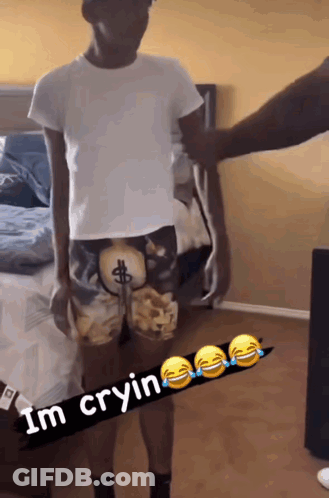 Man In Dollar Sign Shorts Beside Bed GIF