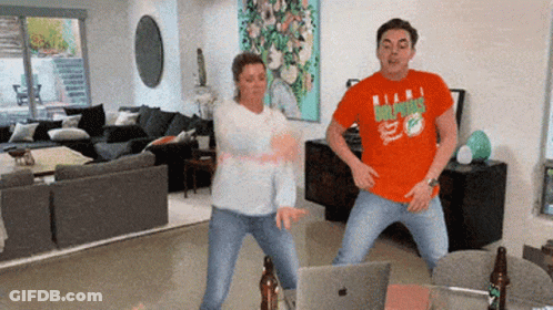 Man In Dolphins Shirt Dancing With Woman GIF