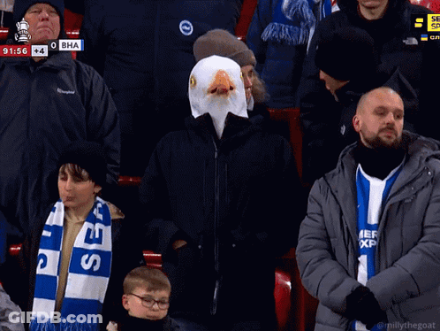 Man In Eagle Mask Sitting In Crowd GIF