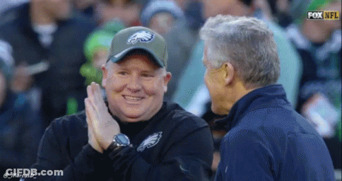 Man In Eagles Hat Talking On Football Field GIF