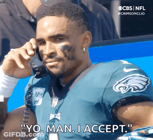 Man In Eagles Jersey Talking On Phone GIF