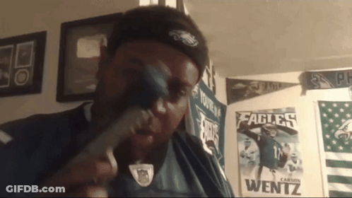 Man In Eagles Shirt Holding Hammer GIF