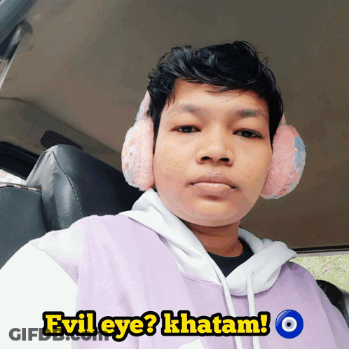 Man In Ear Muffs And Purple Shirt Saying Evil Eye GIF