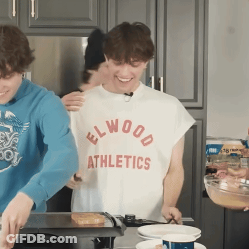 Man In Elwood Athletics Shirt Cooking GIF