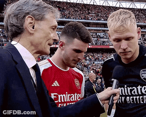 Man In Emirates Shirt Interviewed By Two Men GIF