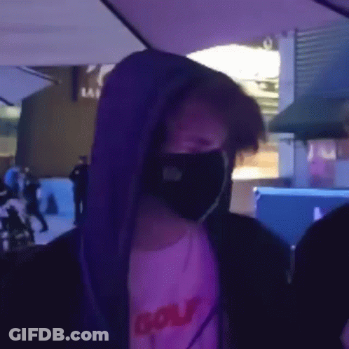 Man In Face Mask And Purple Hoodie Under Umbrella GIF