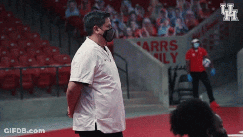 Man In Face Mask In Front Of Arrs Family Sign GIF