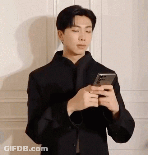 Man In Face Mask Looking At Phone GIF